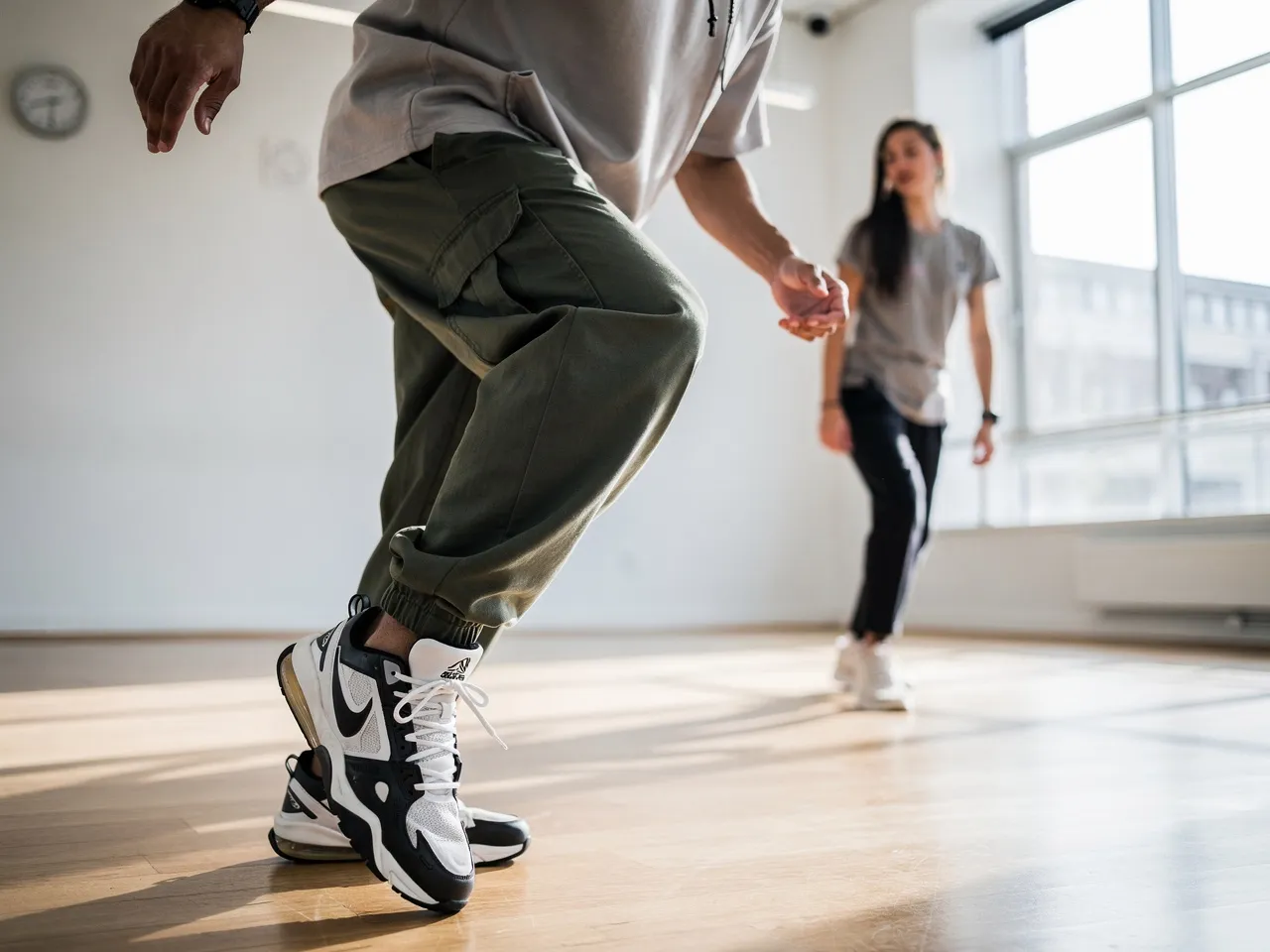 Dance instructor demonstrating hip hop move to student