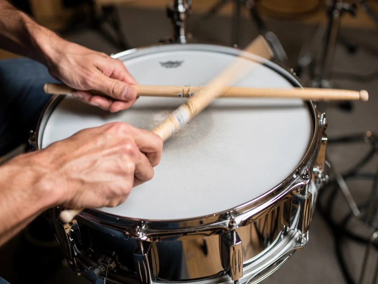 Close-up of drummer's hands hitting a snare drum.